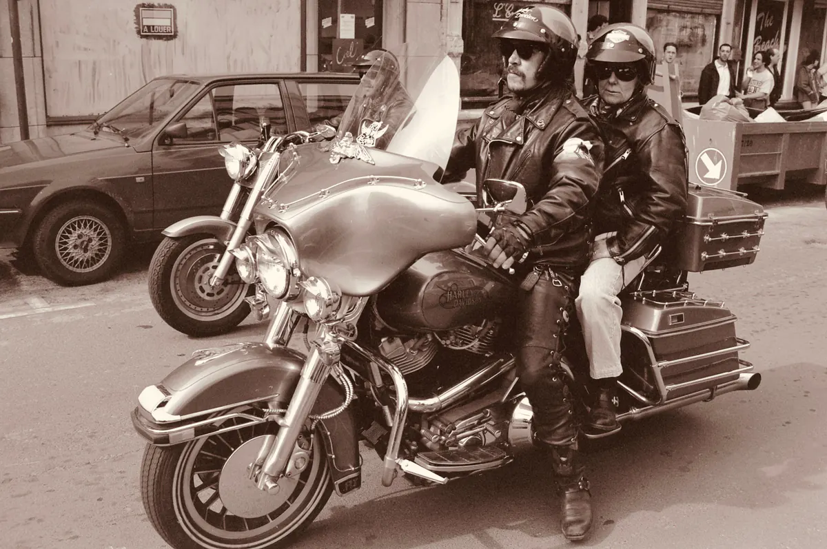 Illustrative stock photograph of two mature motorcycle riders seated on a touring motorcycle