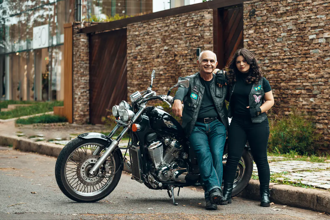Illustrative stock photograph of two adults standing together beside a motorcycle