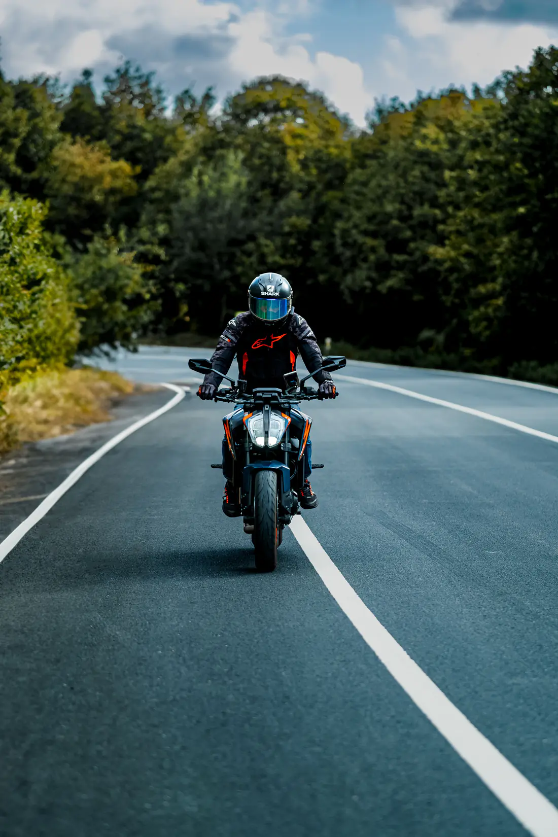 Illustrative stock photograph of a motorcycle rider on a forest road