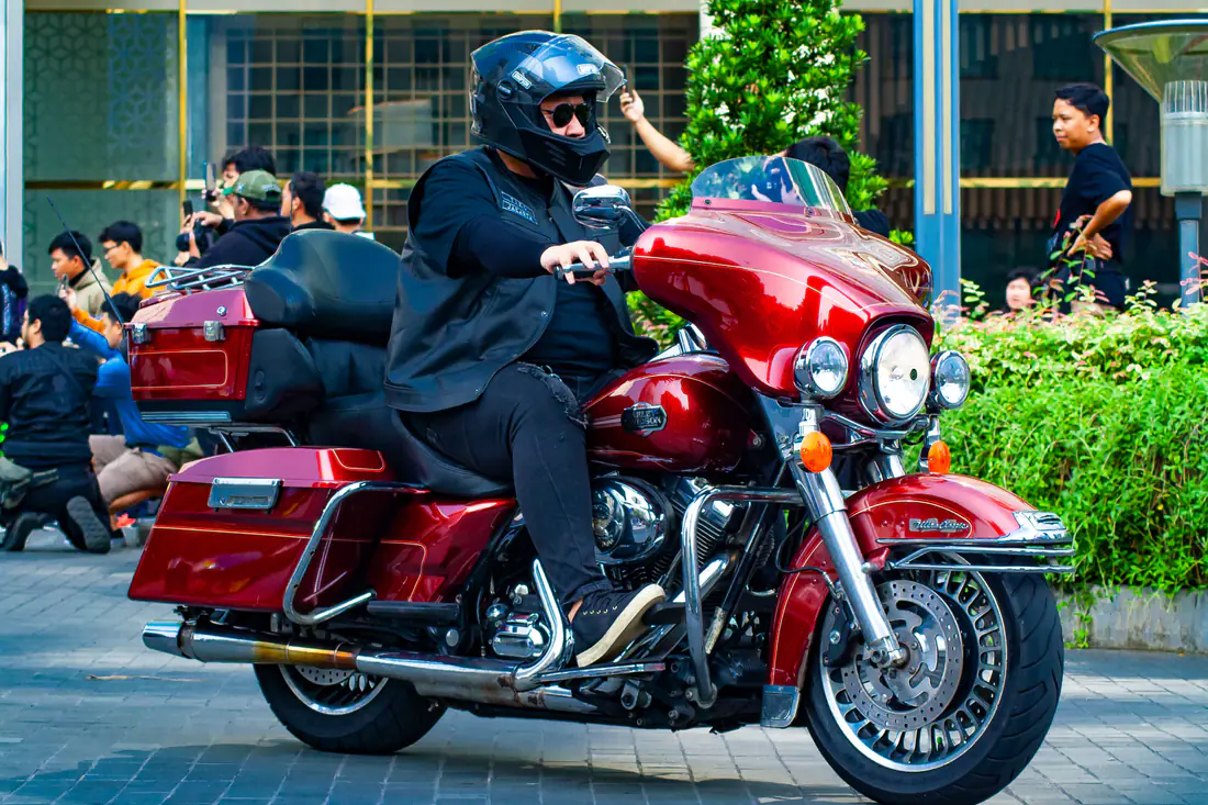 Illustrative stock photograph of a rider on a red touring motorcycle in a city