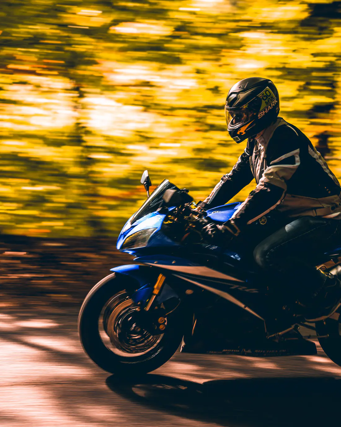 Illustrative stock photograph of a sport motorcycle rider moving along a road