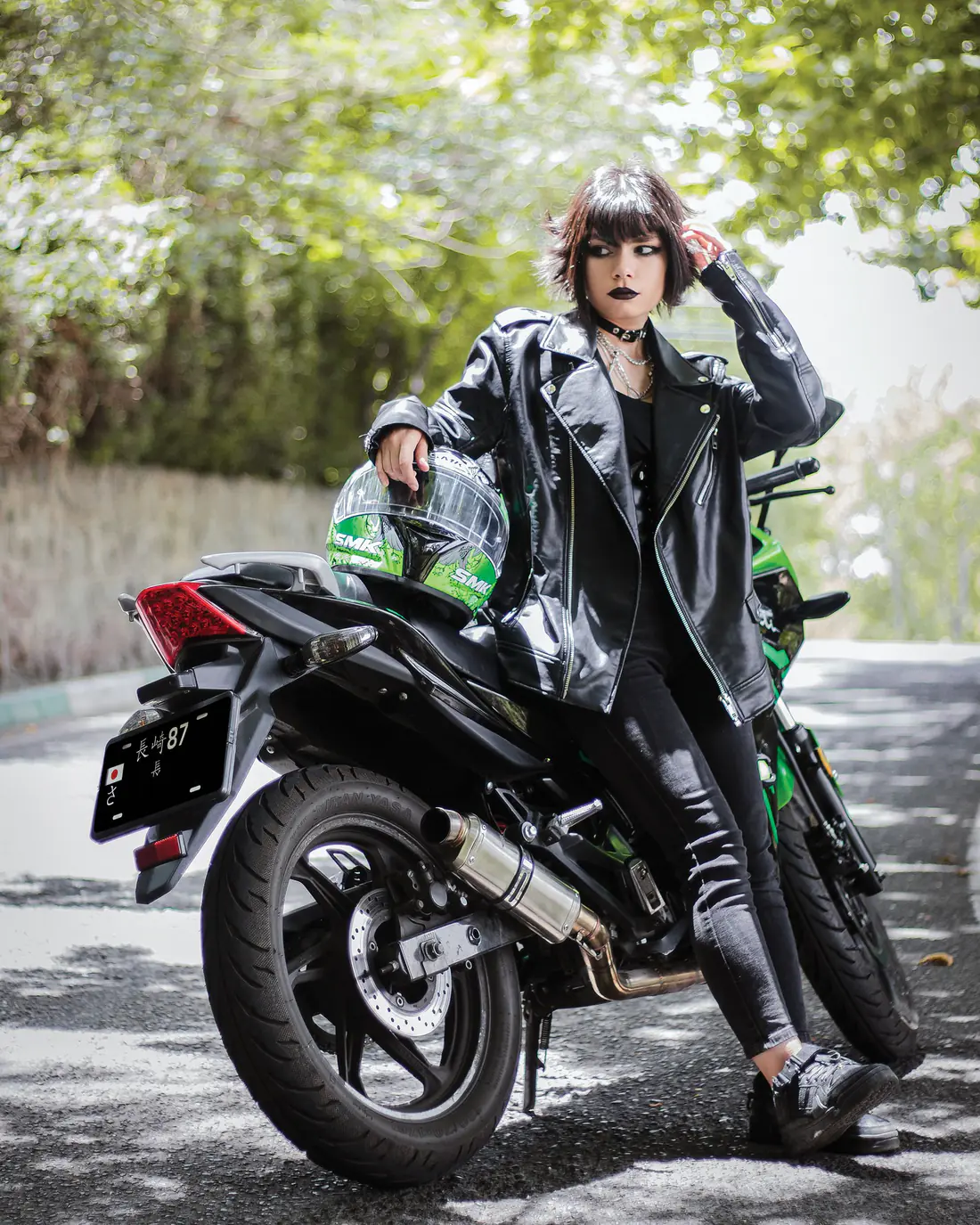 Illustrative stock photograph of a woman standing beside a motorcycle